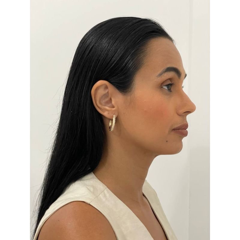 Argola aberta cravejada com zircônia formato oval banhado a ouro 18k